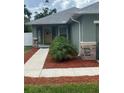Inviting walkway framed with mulch and a small palm lead to the front door, with stone accents at 3505 Gloria Ave, Plant City, FL 33563