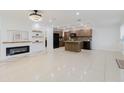 Open-concept living space featuring fireplace and a modern kitchen with island and black appliances at 4902 Murray Hill Drive, Tampa, FL 33615