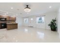 Bright living room with modern lighting, tile flooring, and open layout to the kitchen at 4902 Murray Hill Drive, Tampa, FL 33615