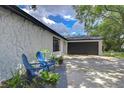 Property showing manicured garden, sitting area, textured facade and access to garage at 4911 Country Aire Ln, Tampa, FL 33624
