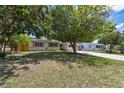 A home with a well-kept lawn is shaded by a large, lush tree at 5010 8Th N Ave, St Petersburg, FL 33710