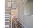 Bright foyer featuring hardwood floors, tall ceilings, a staircase with wooden handrail, and elegant archway at 5236 Treig Ln, Wesley Chapel, FL 33545