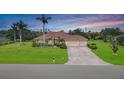 Stunning single-story home with a brick-paved driveway, terracotta roof, lush green lawn, and beautiful palm trees at 6120 9Th Avenue Ne Cir, Bradenton, FL 34212