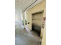 Exterior view of a building elevator featuring a stainless steel door and floor indicator at 6931 Stones Throw N Cir # 5210, St Petersburg, FL 33710