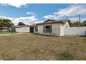 Tan single-story home featuring a gray garage door, driveway, and a well-maintained lawn at 717 Fairmont Dr, Brandon, FL 33511