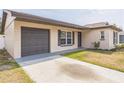 Single-story home with gray garage door, manicured lawn, and sidewalk leading to the front door at 717 Fairmont Dr, Brandon, FL 33511