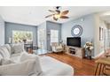 Bright living room with hardwood floors, a ceiling fan, and views to the outside balcony at 10764 70Th Ave # 6210, Seminole, FL 33772