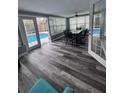 Bright sunroom features wood-look flooring, a ceiling fan, and offers seamless access to the pool at 11889 Walker Ave, Seminole, FL 33772