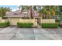 Charming exterior with a private courtyard, mature landscaping, and an attached garage at 120 Colony South Dr, Tarpon Springs, FL 34689