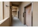 Neutral-toned hallway leads to a wood-paneled elevator and doorway at 1241 S Martin Luther King Jr Ave # 302, Clearwater, FL 33756