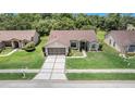 An aerial view of a single-story home, showcasing its neat landscaping and proximity to lush greenery at 13819 Stoneridge Dr, Hudson, FL 34669