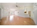Spacious living room with light-colored hardwood floors, white walls and a ceiling fan at 13819 Stoneridge Dr, Hudson, FL 34669