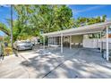 View of the front yard showing the covered car port and screened in porch at 1505 E 99Th Ave, Tampa, FL 33612