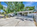 View of the front yard showing the covered car port and screened in porch of the home at 1505 E 99Th Ave, Tampa, FL 33612