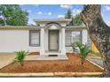 Charming front entrance featuring columns, fresh mulch, and manicured landscaping at 1801 E Navajo Ave, Tampa, FL 33612