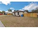 A view of the house and its backyard with a wood fence at 1818 Kim Acres Ln, Dover, FL 33527