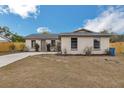 Single-story home featuring a well-manicured lawn, front garden beds and a freshly-painted exterior at 1818 Kim Acres Ln, Dover, FL 33527