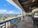 Covered patio with dark wood ceilings, fans, and a summer kitchen overlooks the pool and waterfront views at 191 1St W St, Tierra Verde, FL 33715