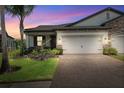 Beautiful one-story home exterior at twilight with a brick driveway at 19323 Hawk Valley Dr, Tampa, FL 33647