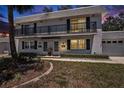 Charming condo at dusk with a balcony, manicured lawn, and a one-car garage in a tranquil neighborhood at 202 Mindy Dr, Largo, FL 33771
