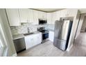 Modern kitchen with white cabinets, stainless steel appliances, and luxury vinyl plank flooring at 2205 Belleair Rd # A36, Clearwater, FL 33764