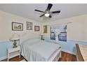 Bedroom features hardwood floors, a window, ceiling fan and a bed with white accents at 22115 Laver Ln, Land O Lakes, FL 34639