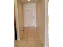Hallway featuring neutral walls and tile floors leading to a bright white door at 2424 W Tampa Bay Blvd # M-201, Tampa, FL 33607