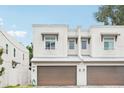 A close-up of a two-story townhome featuring a 2-car garage, decorative window coverings, and a contemporary facade at 308 S New Jersey Ave # A, Tampa, FL 33609