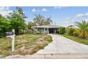 Single-story home with a carport and small front lawn with mailbox on the left at 361 Colonial Ct, Dunedin, FL 34698