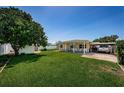 Spacious backyard with lush green grass, a covered patio, and a shed for storage at 5785 15Th N Ave, St Petersburg, FL 33710