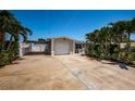 Charming single-story home featuring a one-car garage, covered parking, and tropical landscaping at 5785 15Th N Ave, St Petersburg, FL 33710