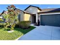 Charming single-story home featuring a well-manicured lawn and a convenient two-car garage at 7114 Fern Garden Ct, Sun City Center, FL 33573