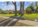 Well-maintained single-Gathering home featuring manicured lawn and attractive landscaping at 854 Village Way, Palm Harbor, FL 34683