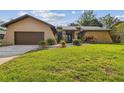 Charming single-Gathering home with well-manicured lawn and attached two-car garage at 854 Village Way, Palm Harbor, FL 34683