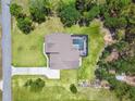Aerial view of a beautiful home with a screened-in pool, complemented by green lawns and mature trees at 9091 Mazette Rd, Weeki Wachee, FL 34613