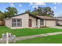 Charming single-story home featuring a well-manicured lawn, colorful landscaping, and attached two-car garage at 10701 Glen Ivy Ln, Tampa, FL 33624