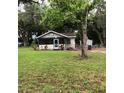 Inviting single-story home featuring a cozy porch and a serene front yard with mature trees at 118 W 122Nd Ave, Tampa, FL 33612