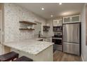 Modern kitchen with granite counters, stainless appliances, and stylish herringbone backsplash at 1250 S Pinellas Ave # 214, Tarpon Springs, FL 34689