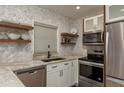 Modern kitchen featuring stainless appliances, granite counters, and open shelving at 1250 S Pinellas Ave # 214, Tarpon Springs, FL 34689