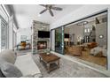 Cozy sunroom with a stone fireplace, sliding glass doors, and an adjacent home office area at 12705 Green Heron Way, Odessa, FL 33556