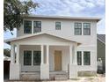 Charming two-story home with white siding, a covered porch, and black-framed windows at 1435 17Th N Ave, St Petersburg, FL 33704