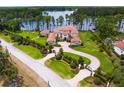 Stunning aerial shot of a waterfront estate featuring lush greenery, a circular driveway, and private lake access at 17124 Crawley Rd, Odessa, FL 33556