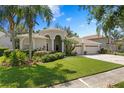 Charming single-story home featuring a three-car garage, paver driveway, manicured lawn and lush landscaping at 17318 Emerald Chase Dr, Tampa, FL 33647