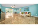 Bright and airy living room with travertine floors and a view into the enclosed sun room at 2485 Indigo Dr, Clearwater, FL 33763