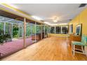 Enclosed sun room with wood floors, large windows, and access to a hot tub at 2485 Indigo Dr, Clearwater, FL 33763