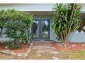 Charming front entrance featuring double doors, brick walkway, and mature landscaping at 2814 W Humphrey St, Tampa, FL 33614