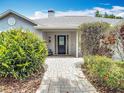 Close-up of the front door entrance with a stone pathway surrounded by lush landscaping at 3001 Regal Oaks Blvd, Palm Harbor, FL 34684