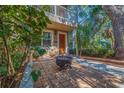 Inviting front patio with brick pavers, fire pit, seating, and lush greenery at 330 Lang N Ct # 1, St Petersburg, FL 33701