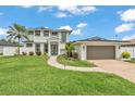 Charming two-story home with a lush front lawn, walkway, and a spacious two-car garage at 330 Palm Ne Is, Clearwater Beach, FL 33767