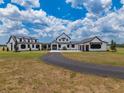 Stunning exterior showcasing a modern farmhouse design with a long drive and ample yard space at 3515 Powerline Rd, Lithia, FL 33547